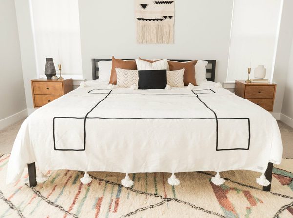 Handwoven Moroccan Pom Pom Blanket • wool throw blanket with black pattern • home decor and cozy snuggling • customizable dimensions.